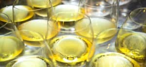 close up of white wine filled wine glasses